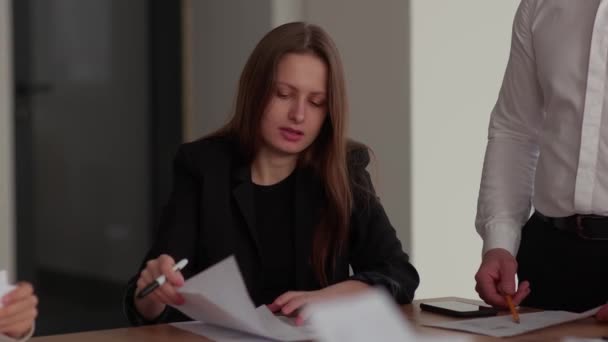 Μια Επιχειρηματίας Κάθεται Ένα Τραπέζι Κρατώντας Έγγραφα Στα Χέρια Της — Αρχείο Βίντεο