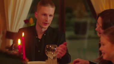 Masada oturan bir adam kızına bir şey söylüyor. Yaşlı bir kadın akşam yemeği sırasında torunlarının saçlarını düzleştirir. Dost canlısı bir aile aynı masada bir restoranda yemek yer. Yüksek