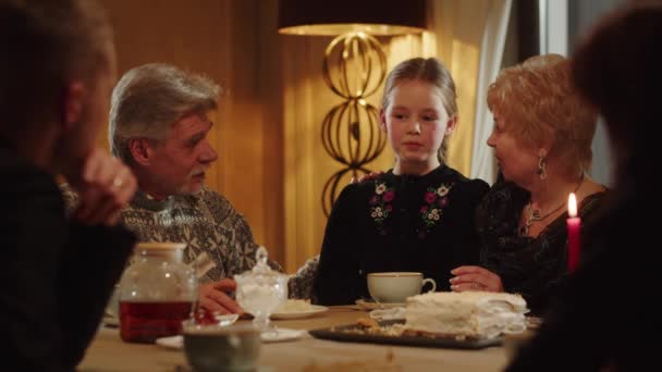 祖父母は茶会中に孫娘と話しています フレンドリーな家族はケーキとティーパーティーを楽しんでいます 高品質4K映像 — ストック動画