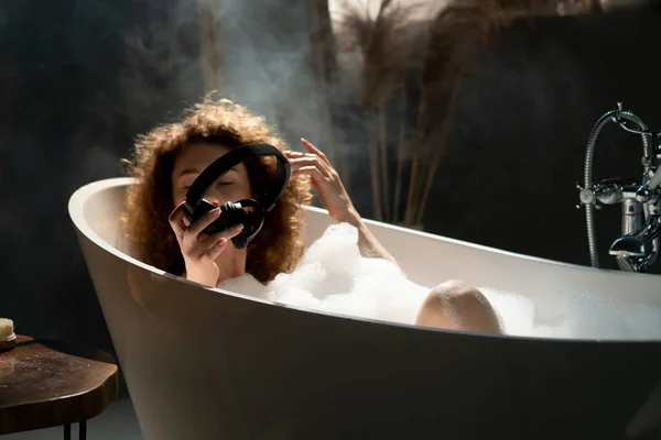 Eine Junge Frau Liegt Einer Badewanne Und Hält Kopfhörer Den — Stockfoto