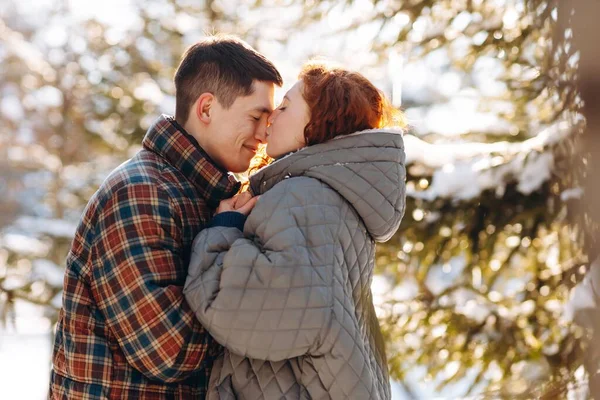 아름다운 머리의 여자가 애인에게 키스하는 배경으로 커플의 낭만적 청소년들은 눈덮인 — 스톡 사진