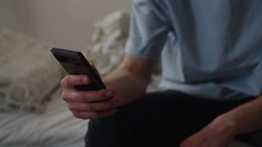 Elinde telefon tutan bir adamın görüntüsü kesilmiş. Mavi tişörtlü bir adam akıllı telefonundaki ihbarları gözden kaçırıyor, sosyal medyada geziniyor. Yüksek kalite 4k görüntü