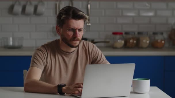 Een Man Met Een Bril Werkt Achter Een Computer Kijkt — Stockvideo