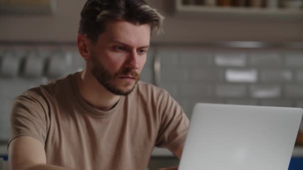 Jovem Sério Está Digitando Teclado Seu Laptop Enquanto Está Sentado — Vídeo de Stock