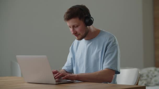Freelancer Masculino Escucha Música Los Auriculares Mientras Trabaja Una Computadora — Vídeos de Stock