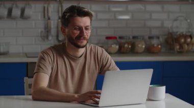 Erkek bir serbest çalışan, yeni bir projenin detaylarını video bağlantısı üzerinden işvereniyle tartışıyor. Gözlüklü gülümseyen bir adam dizüstü bilgisayarının web kamerası aracılığıyla biriyle iletişim kurar. Yüksek kalite 4k görüntü