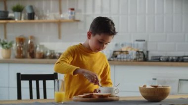 Küçük çocuk mutfakta reçelli sandviç yapıyor. Çocuk yemek pişirmeyi seviyor. Yüksek kalite 4k görüntü