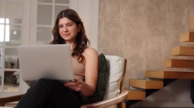 Dizüstü bilgisayarlı bir sandalyede oturan genç bir esmer, web kamerası aracılığıyla iletişim kuruyor. Güzel, uzun saçlı bir kadın gelecek hafta sonu için planlarını arkadaşıyla görüntülü konuşma yoluyla konuşur. Yüksek