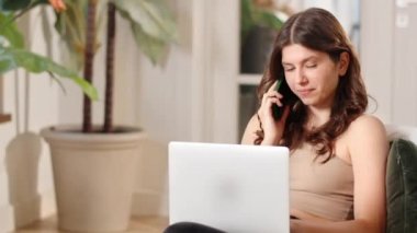 Şirin esmer kadın kucağında dizüstü bilgisayarla bir sandalyede oturuyor ve telefonla konuşuyor. Kadın bir serbest çalışan telefonda işvereniyle yeni bir iş projesini tartışıyor. Yüksek kalite FullHD