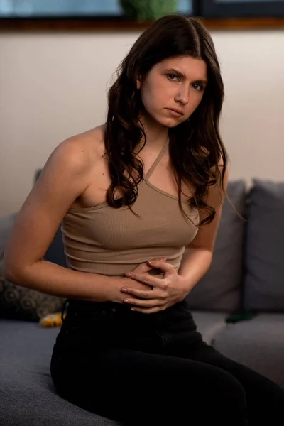 布鲁内特女孩肚子痛 年轻女人用不安的表情摸着她的肚子 月经痛 经期痛 高质量的照片 — 图库照片