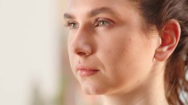 Saçlarını at kuyruğu yapmış genç bir esmer bir tarafa bakıyor. Genç bir kadın gözlerini açar ve dikkatlice yana bakar. Yüksek kaliteli FullHD görüntüler