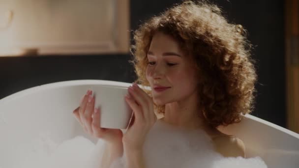 Köpükle Banyo Yaparken Elinde Bardak Dolusu Içki Olan Kıvırcık Kadının — Stok video