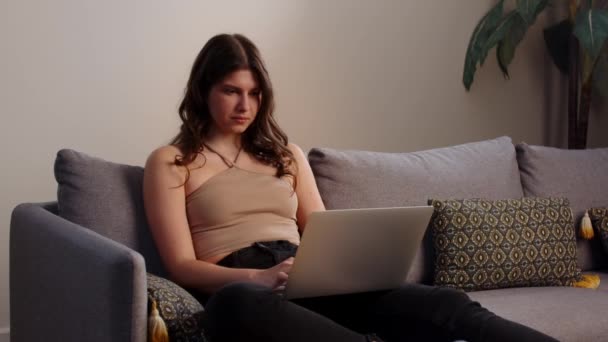 Ung Kvinna Sitter Soffa Med Laptop Knät Och Surfar Internet — Stockvideo