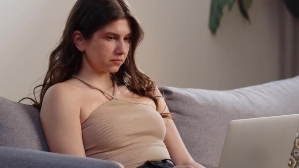 Uma Morena Uma Camiseta Bege Está Sentada Sofá Com Laptop — Vídeo de Stock