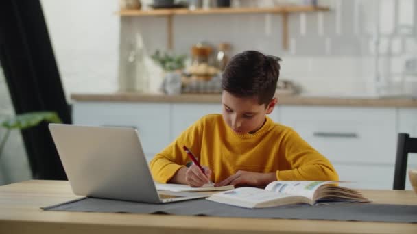 Çocuk Bir Kitap Dizüstü Bilgisayarla Bir Masada Oturuyor Bir Deftere — Stok video