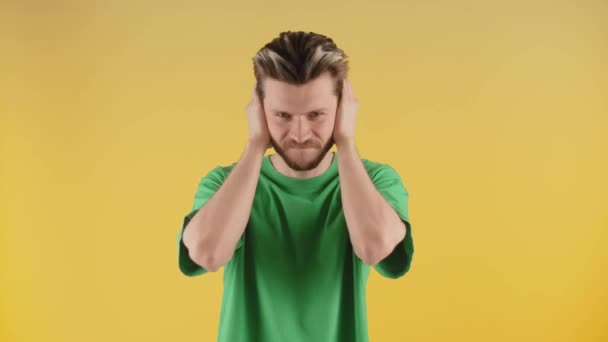 緑のTシャツを手で耳を覆う男 髭の男は聞きたくない 高品質4K映像 — ストック動画