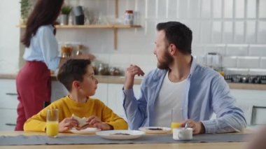 Bir baba kahvaltıda oğluna bir şey söyler. Küçük bir çocuk kahvaltıda takviye istiyor. Yüksek kalite 4k görüntü