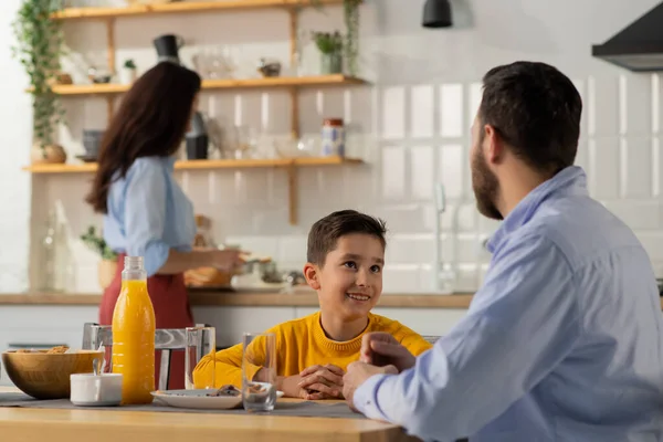 Niño Sienta Mesa Comunica Con Padre Mientras Madre Prepara Desayuno — Foto de Stock