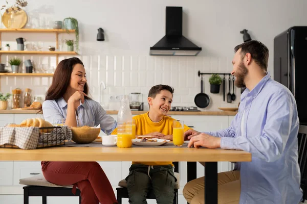 Дружелюбная Семья Завтракает Кухонным Столом Улыбающийся Мальчик Сидит Столом Своими — стоковое фото