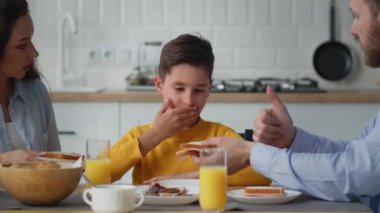 Baba oğluna sandviç yemesini teklif eder, ama oğlu reddeder. Sarı kazaklı çocuk babasının ona verdiği peynirli sandviçi yemek istemiyor. Yüksek kalite 4k görüntü