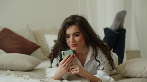 Odasında Yatarken Telefon Mesajlarını Okuyan Gülen Kız Akıllı Telefonlu Mutlu — Stok video