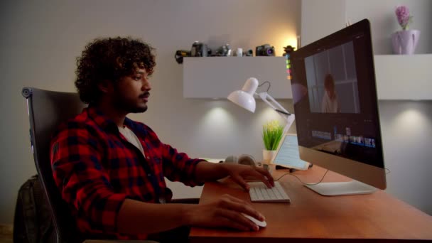 穿着格子衬衫的年轻人正在剪辑录像 视频编辑器与来自家庭的计算机一起工作 高质量的4K镜头 — 图库视频影像
