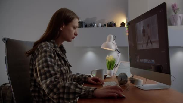 フリーランスの女の子編集ビデオ彼女のコンピュータ上で ビデオグラファーは自宅から働いています 高品質4K映像 — ストック動画