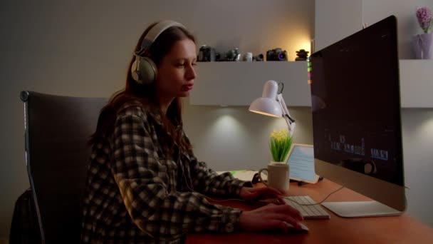 Όμορφη Κοπέλα Ακουστικά Απολαμβάνει Μουσική Ενώ Έκδοση Βίντεο Στον Υπολογιστή — Αρχείο Βίντεο