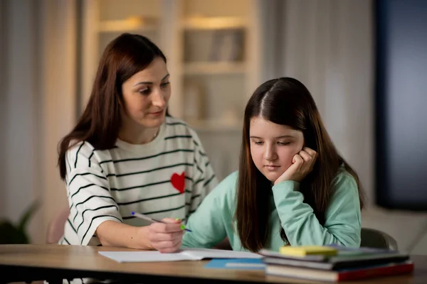 어머니는 딸에게 과제를 해결하는 방법을 설명한다 엄마와 아이들은 집에서 숙제를 — 스톡 사진