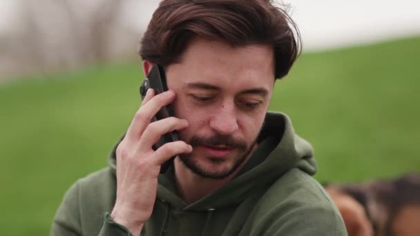 Homem Morena Barbudo Falando Telefone Enquanto Sentado Grama Parque Homem — Vídeo de Stock
