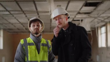 İnşaat müfettişi inşaat işçisiyle konuşuyor. İnşaat alanında mimar mühendisler bir şey tartışıyorlar. Yüksek kalite 4k görüntü