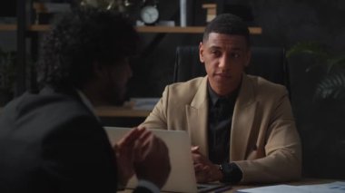 İş ortakları şirketin mevcut mali konumunu tartışıyor. Kahverengi ceketli siyahi bir erkek işadamı, ortağı ile şirket için yeni bir finansal modeli tartışıyor. Yüksek kalite