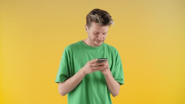 Seorang Pemuda Dengan Kaos Hijau Melihat Sesuatu Smartphone Nya Dengan — Stok Video