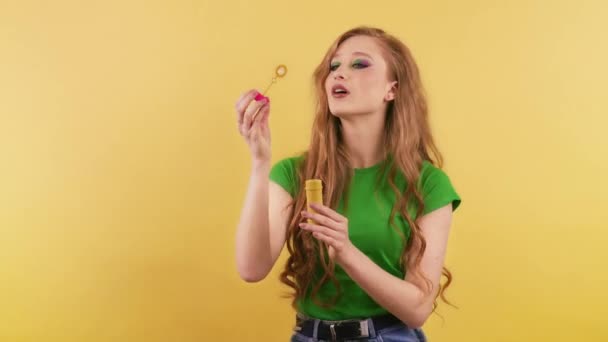 Женщина Стоит Оранжевом Фоне Пускает Мыльные Пузыри Веселая Рыжая Зеленой — стоковое видео