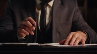 Bir kağıt parçasına bir şeyler yazan takım elbiseli bir adamın görüntüsü. Bir iş adamı masaya oturur ve bir sözleşme imzalar. Yüksek kalite 4k görüntü