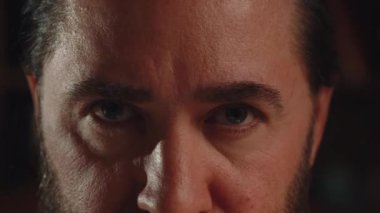 Kameraya dikkatle bakan bir adamın kırpılmış yüzü. Sakallı bir adam gözlerini açar ve kameraya bakar. Yüksek kalite 4k görüntü