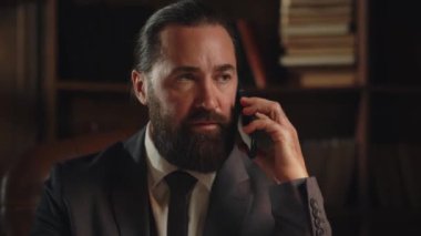 Ofisinde oturan düzgün sakallı bir adam telefonu kaldırır ve iş ortağını arar. Erkek işadamı telefonda iş ortağıyla yeni bir girişim hakkında konuşuyor. Yüksek kalite 4k