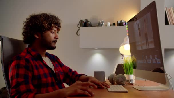 穿着红衫的焦点是在电脑上编辑视频 录像制作者在家里工作 高质量的4K镜头 — 图库视频影像