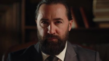 Katı takım elbiseli bir adam kameraya bakar ve şakağına masaj yapar. Siyah ceketli sakallı bir adam kameranın önünde oturur ve bir şey düşünür. Yüksek kalite 4k görüntü