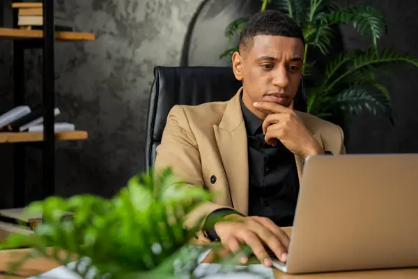 パソコンの画面を見ながらテーブルに座っているのは 一見の価値があるビジネスマン 男性実業家は彼の自宅のオフィスに座って 彼の会社の財務諸表の電子コピーを研究します — ストック写真
