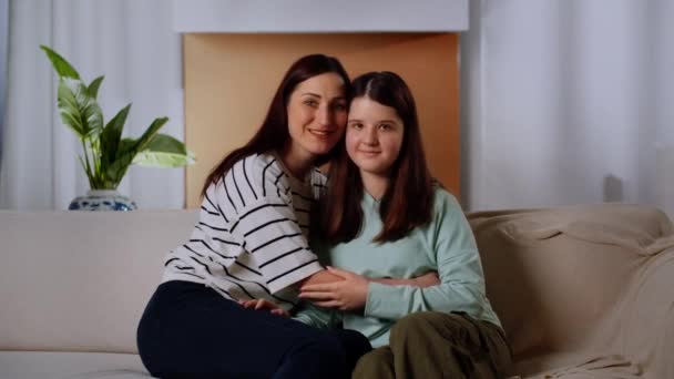Mama Córka Siedzą Kanapie Uśmiechem Patrzą Kamerę Brunetka Przytula Córkę — Wideo stockowe