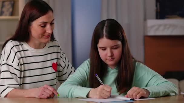 Een Zorgzame Moeder Helpt Haar Dochter Met Haar Huiswerk Een — Stockvideo