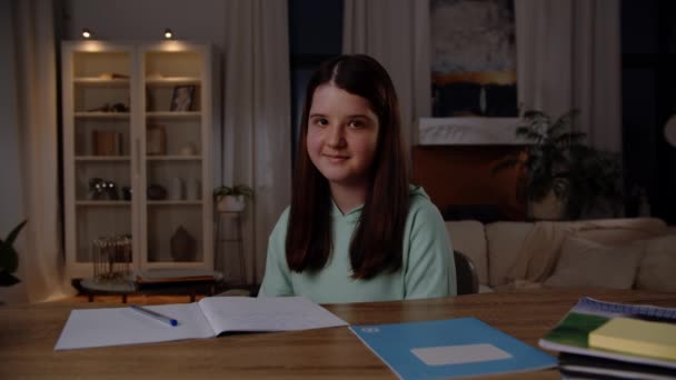 Smiling Girl Sits Desk Which Notebooks Lie Waves Her Hand — Stock Video