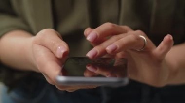 Bir kadın elinde bir akıllı telefon tutar ve çabucak bir mesaj yazar. Akıllı telefon kullanan bir kadın görüntüsü. Yüksek kalite 4k görüntü