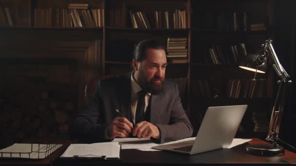 Бізнесмен Позує Камерою Сидячи Своїм Столом Своєму Домашньому Офісі Бородатий — стокове відео