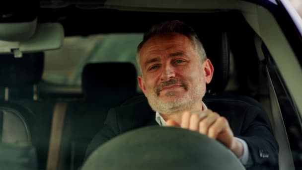 一个满脸笑容的男人坐在车里 双手碰碰方向盘 一个穿着西装 坐在方向盘后面喝咖啡的微笑男子的正面形象 — 图库视频影像