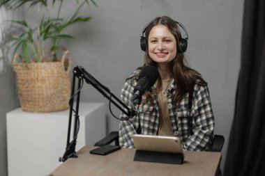 Kulaklıklı gülen kız podcast yapıyor. Esmer genç bayan radyoda çalışıyor. Yüksek kalite fotoğraf