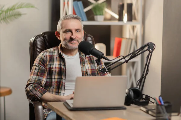 Kareli tişörtlü son sınıf öğrencisi podcast yapıyor. Profesyonel mikrofonlu dizüstü bilgisayarı olan neşeli bir blogcu. Yüksek kalite fotoğraf