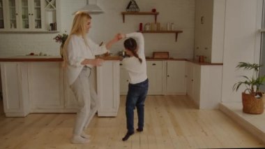 Evde kızıyla dans eden mutlu sarışın kadın. Anne ve kızının eğlenmesini uzun uzadıya izlemek. Yüksek kalite 4k görüntü