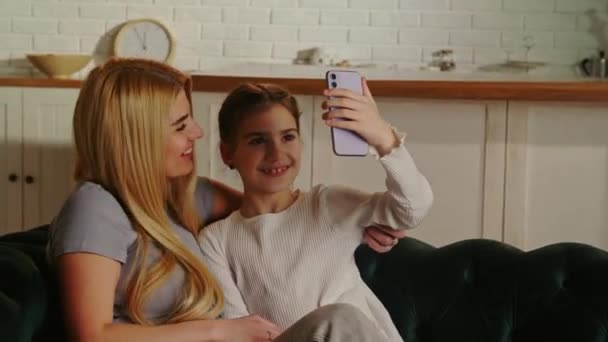 笑顔の女の子は母親と一緒に自撮りしています 一緒に写真のポーズをとってくれる幸せなお母さんと娘 高品質4K映像 — ストック動画